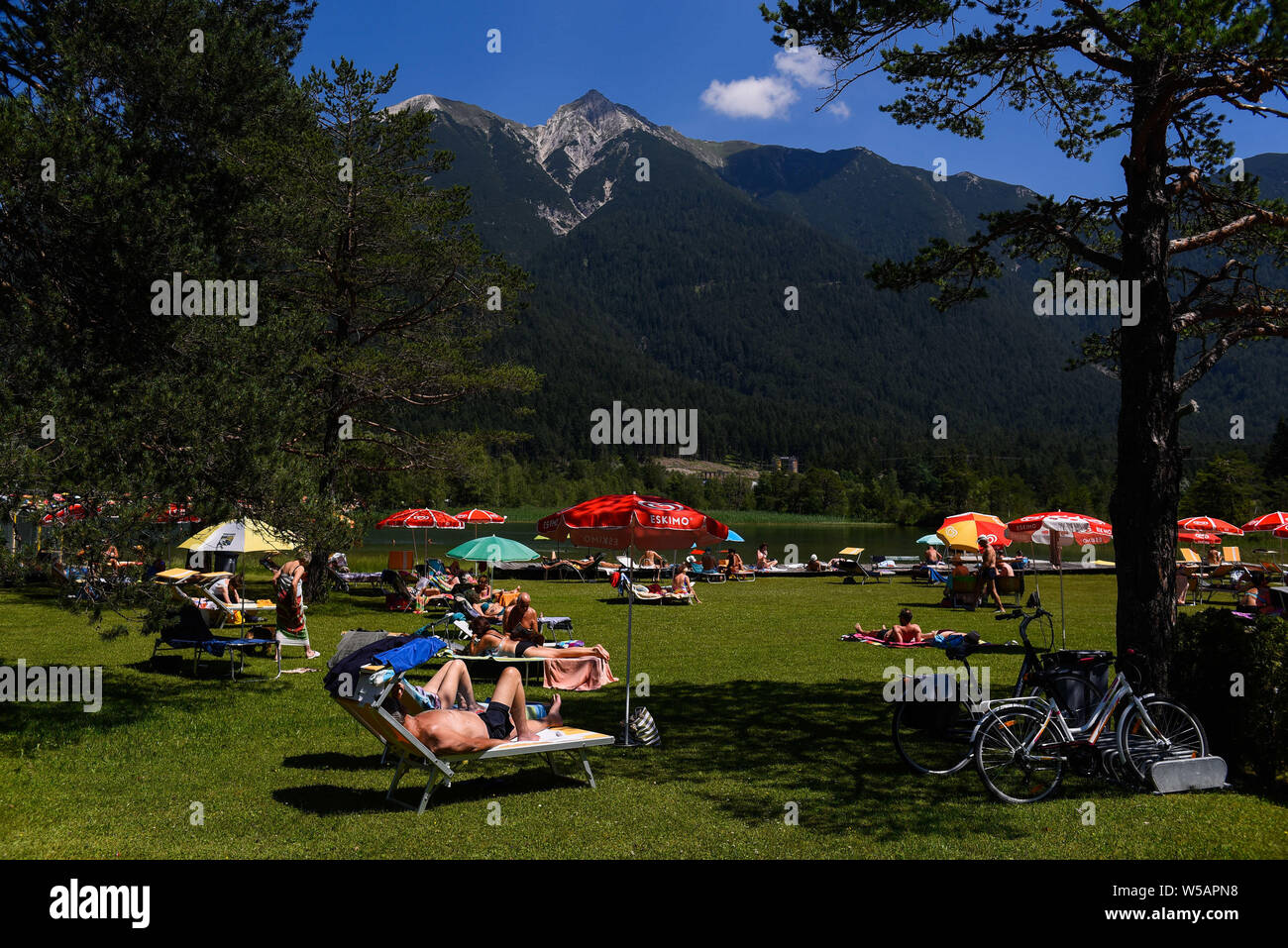 Juli 23, 2019, Seefeld, Österreich: Menschen Sonnenbaden an den Ufern des Wildsee in Seefeld, Tirol ist eine westliche österreichischen Staates in den Alpen für seine Skigebiete bekannt, Wanderwege und historischen Orten. Credit: Omar Marques/SOPA Images/ZUMA Draht/Alamy leben Nachrichten Stockfoto