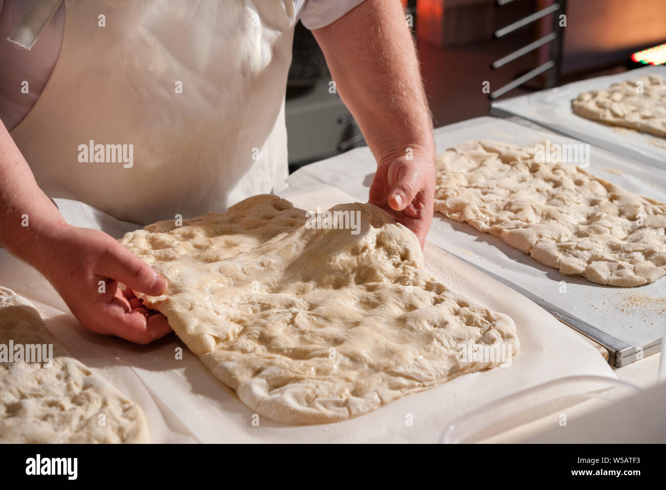 Bäcker bereitet eine focaccia Teig auf einer Arbeitsplatte. Stockfoto
