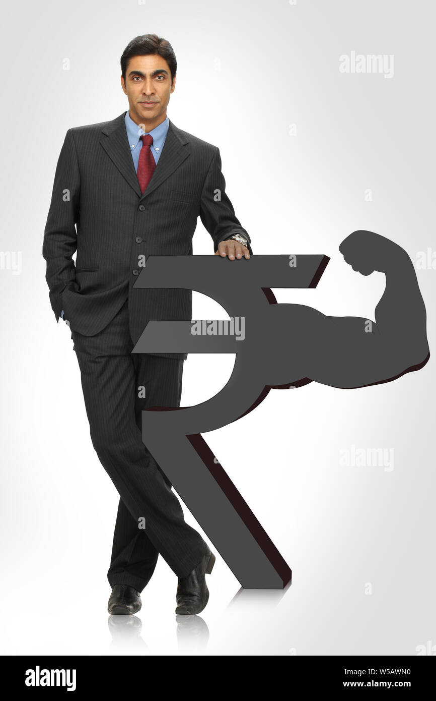 Geschäftsmann steht mit Rupie-Symbol Stockfoto