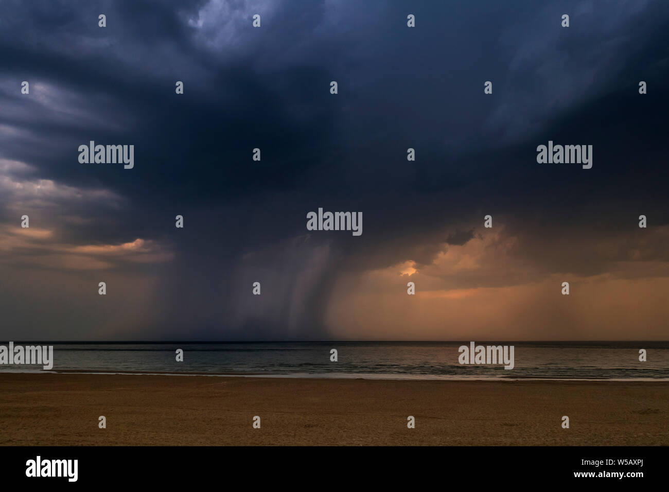 Gewitter, dunkle Regenwolken und Wolkenbruch/Sprühflutanlage über das Meer während der Hitzewelle/Hitzewelle im Sommer Stockfoto