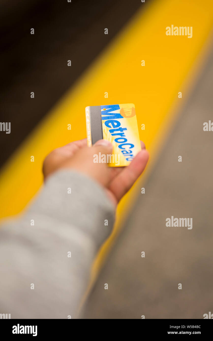 NEW YORK, USA - 27. AUGUST 2017: MetroCard in der Hand des jungen Mannes auf dem New Yorker U-Bahn. MetroCard ist die Zahlungsmethode für die New Yorker U-Bahn Stockfoto