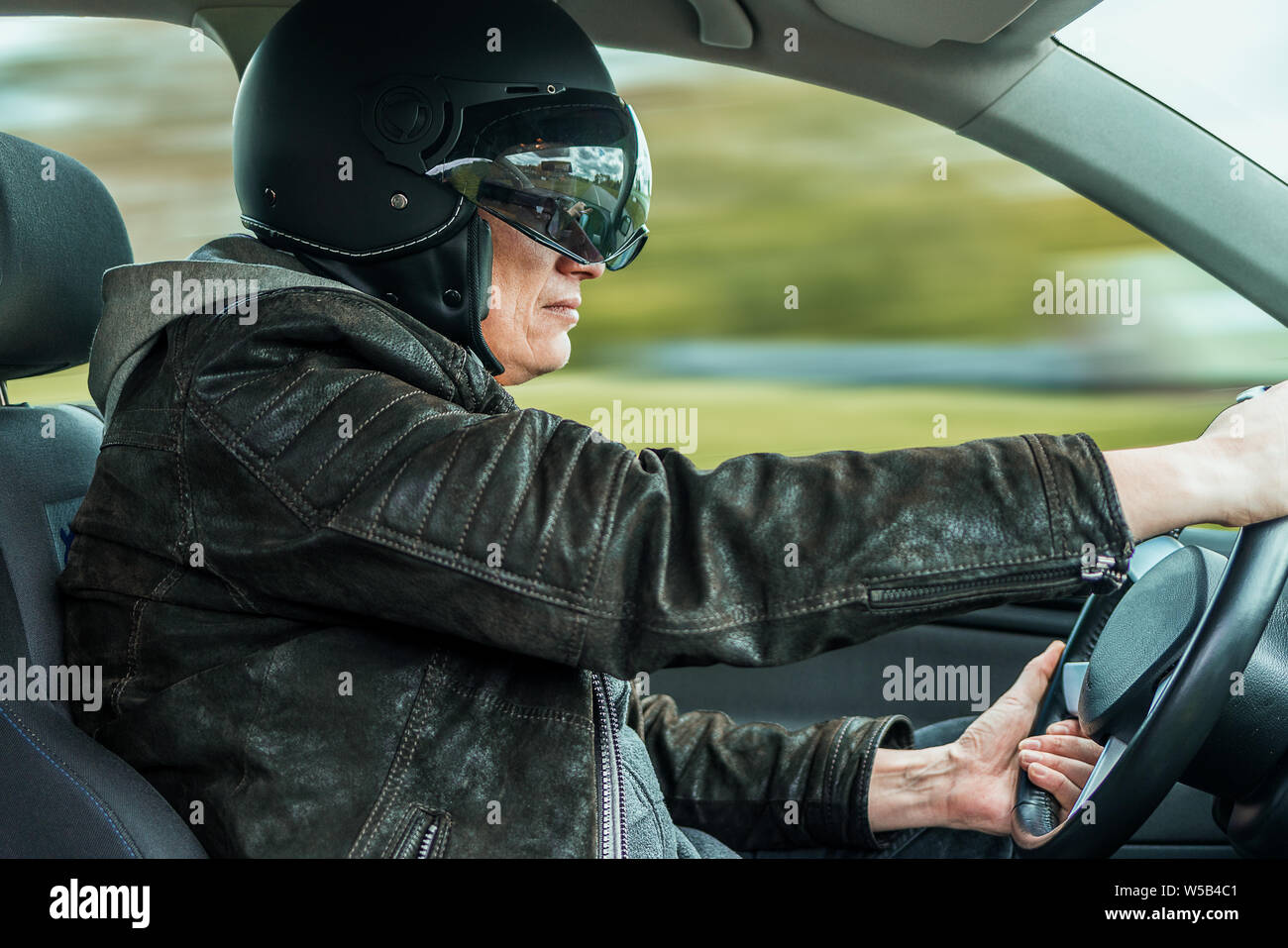 Ein Racer mit Helm fährt ein schnelles Auto Stockfoto
