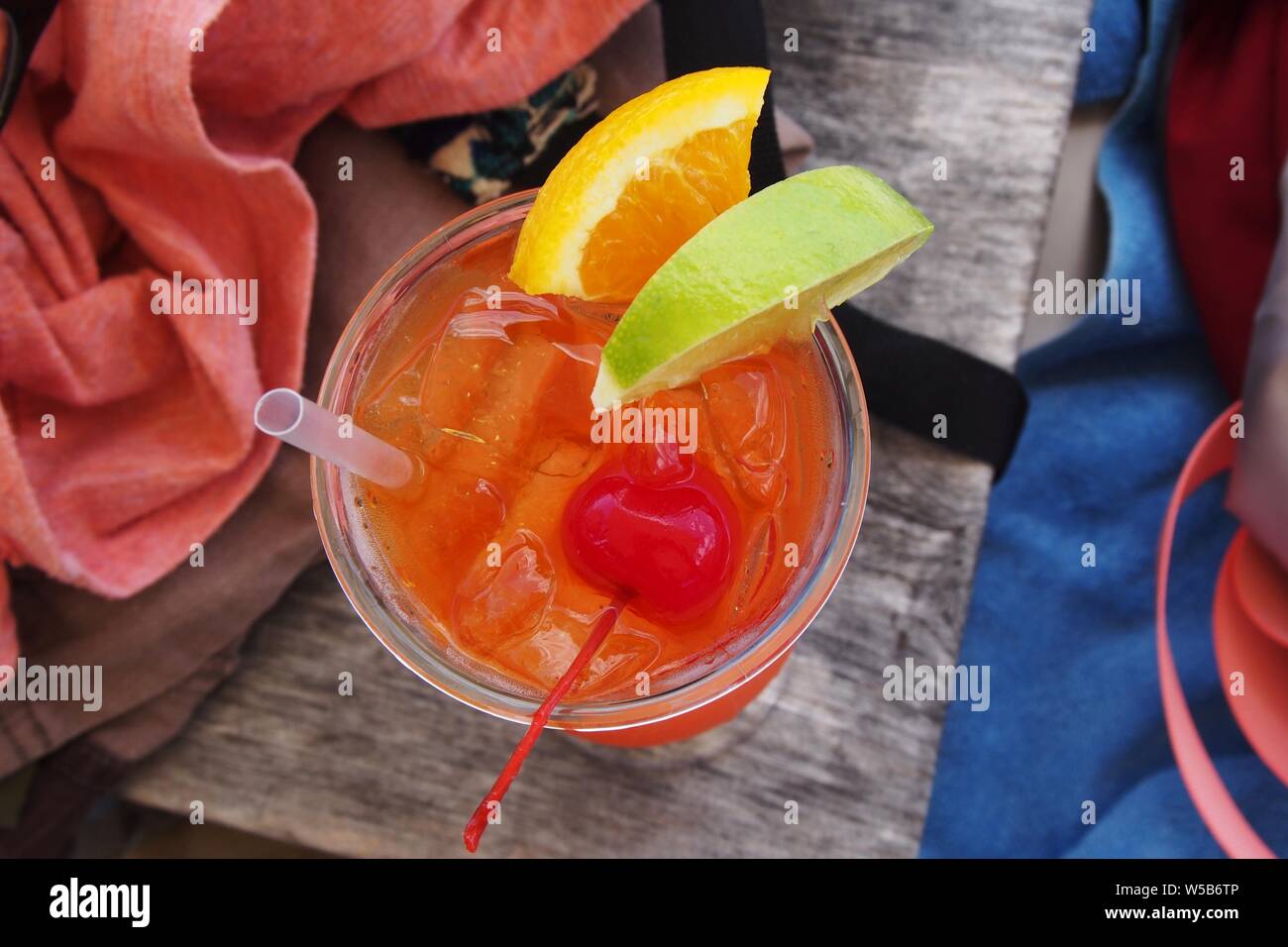Von oben nach unten geschossen von einem Rum punch auf einem Holztisch mit Strandausrüstung, Anguilla, BWI. Stockfoto