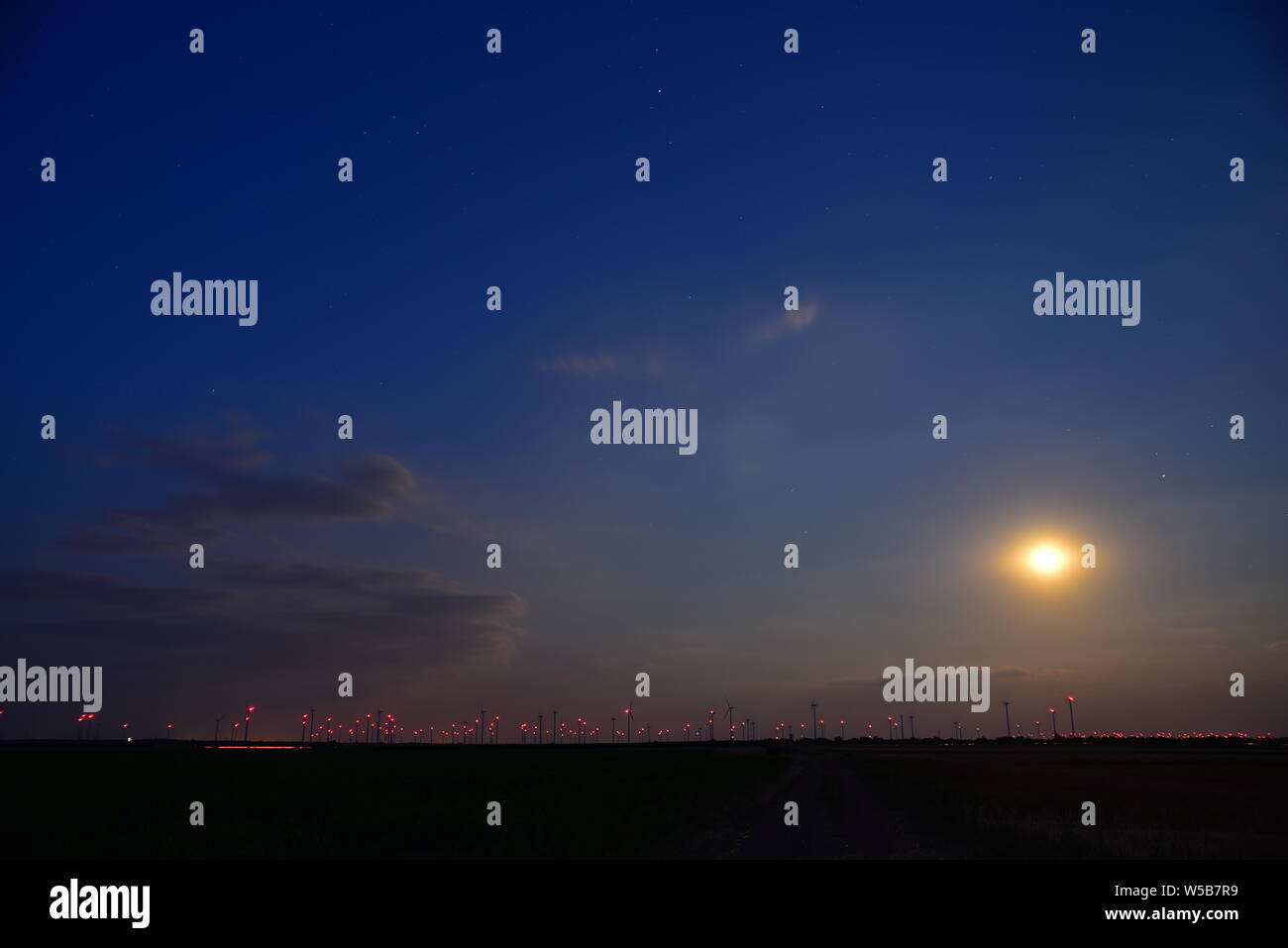 Vollmond über dem Burgenland Ebene mit blinkenden roten Lichter von Windenergieanlagen grüner Strom in der Nacht in Österreich zu erzeugen. Stockfoto