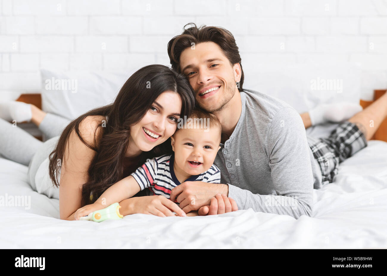 Happy tausendjährigen Familie Abbinden auf dem Bett mit Baby Stockfoto