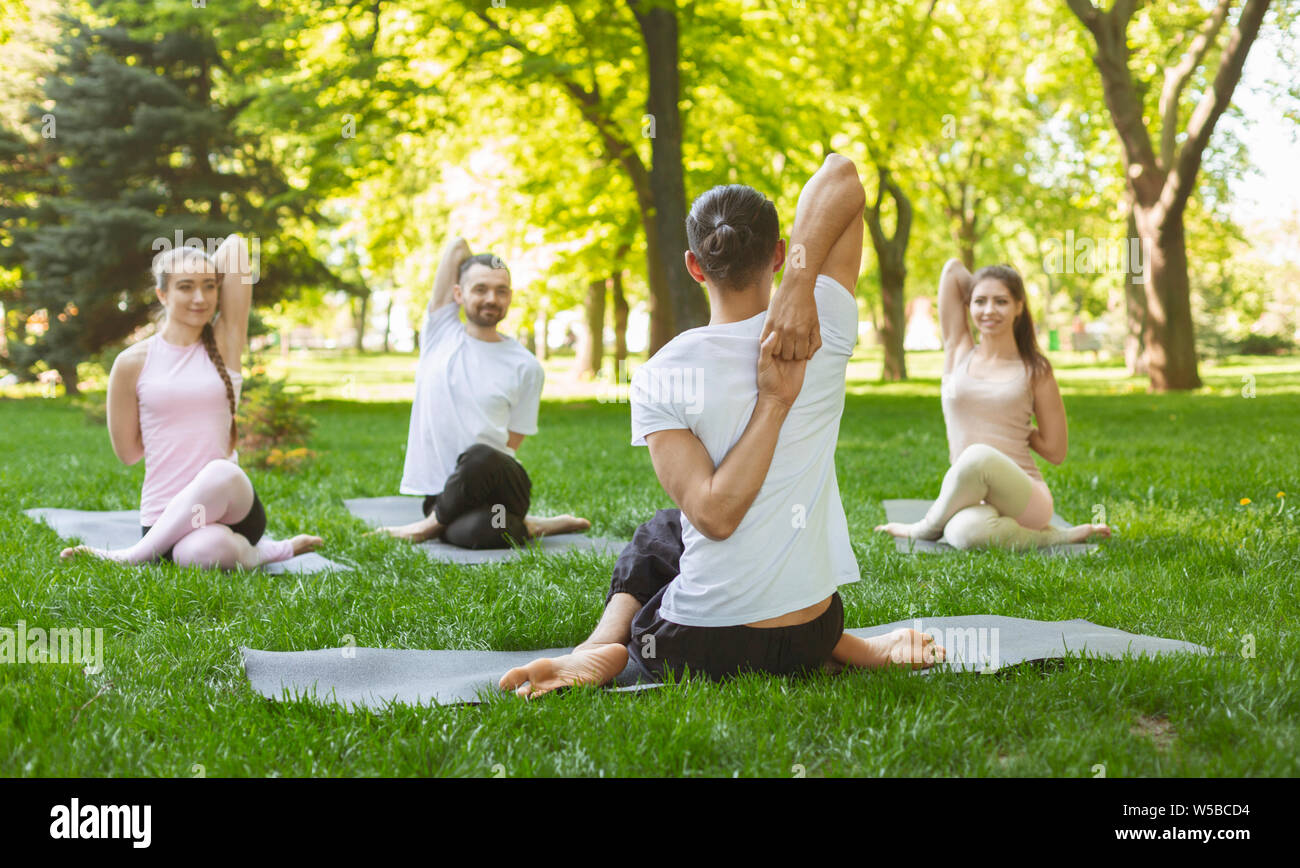 Gruppe von Menschen üben Yoga, sitzen in Kuh Gesicht Übung Stockfoto