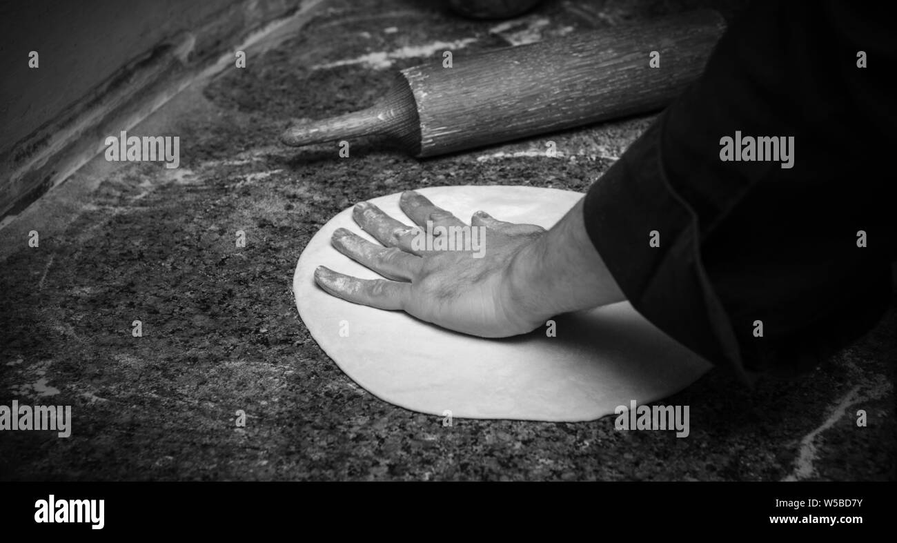 Koch rolling Teig für Pizza, Nahaufnahme Stockfoto