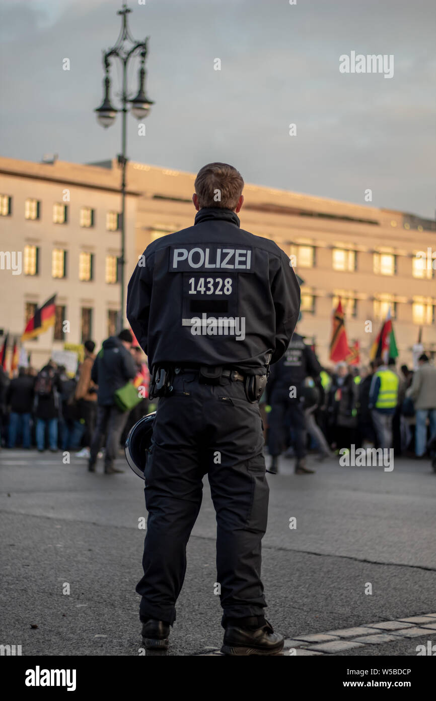 Ein deutscher Polizist bewacht eine Schutztür am Rande einer Demonstration Stockfoto