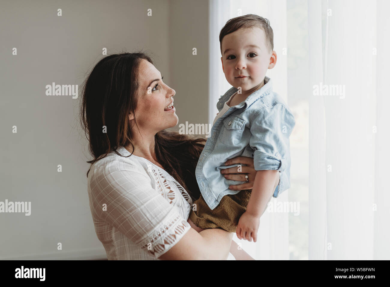 Seitenansicht von Mutter auf Kind Sohn in natürlichem Licht studio Stockfoto