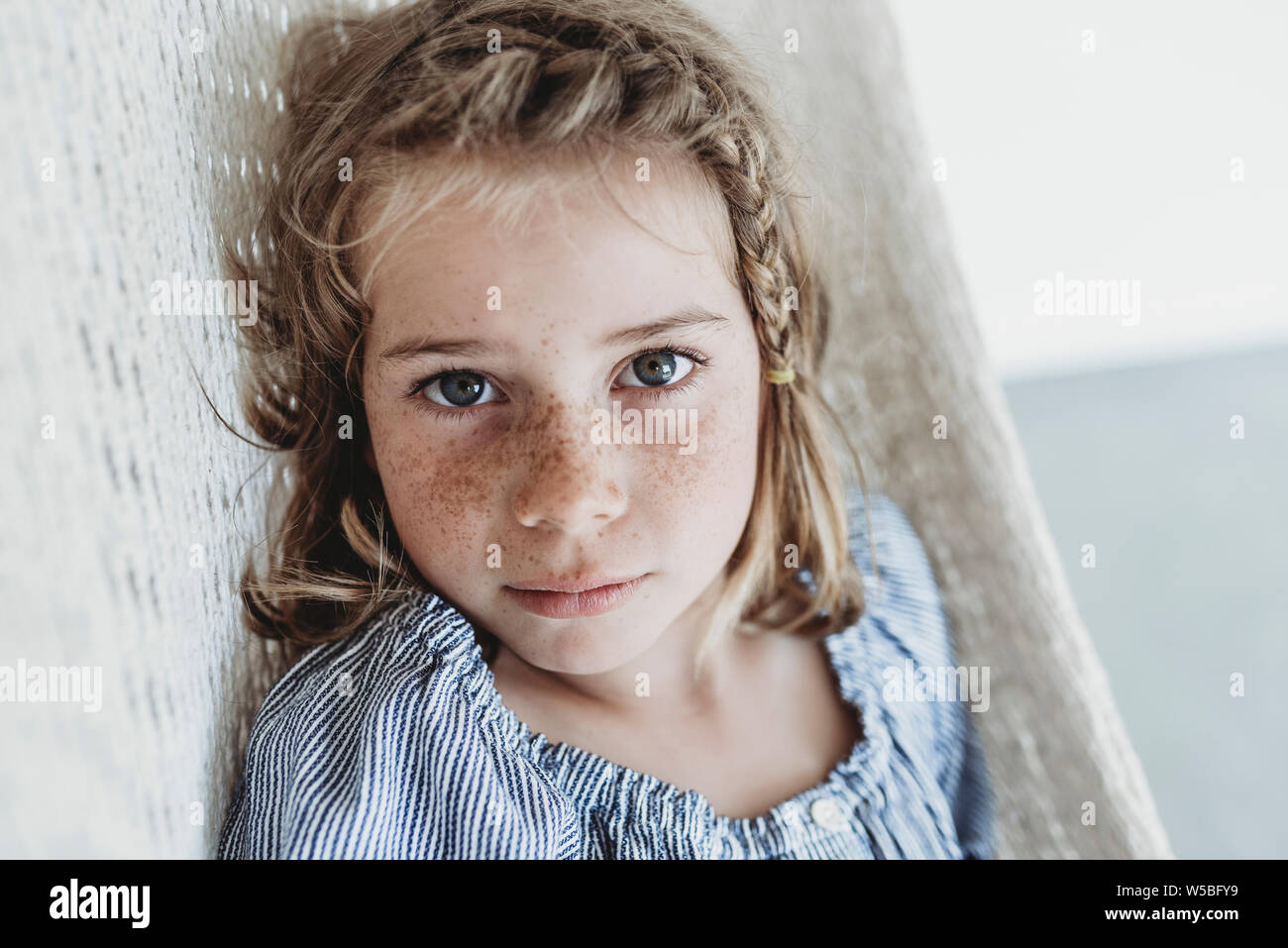 Porträt von Ernst schulpflichtigen Mädchen mit Zopf in ihrem Haar Stockfoto