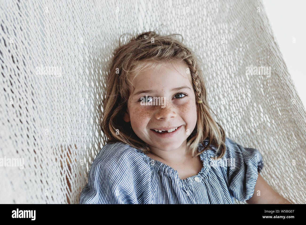 Portrait von lächelnden schulpflichtigen Mädchen mit Zopf in ihrem Haar Stockfoto