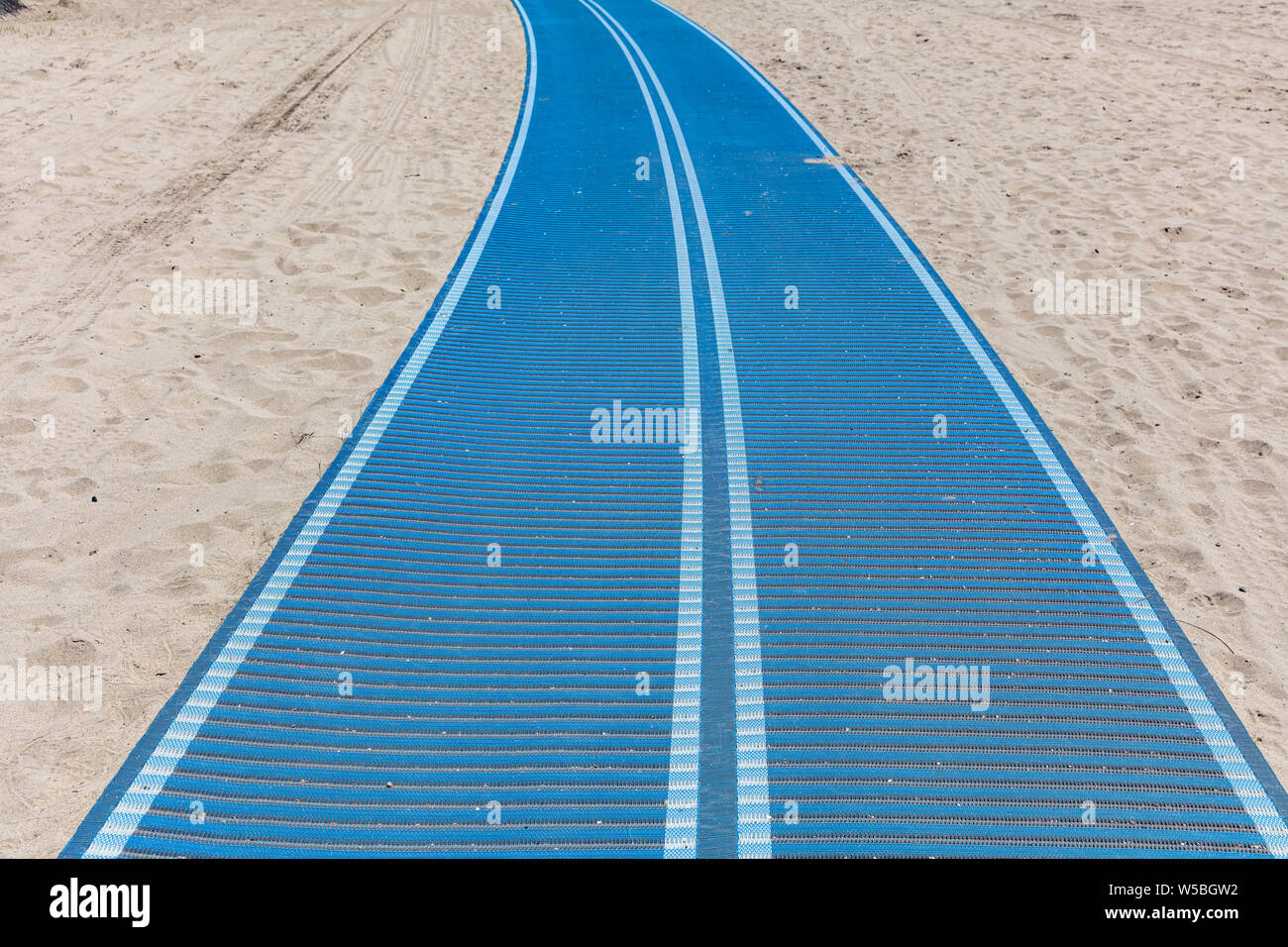 Gehweg blaue Farbe auf dem sandigen Strand, zum Meer. Sonniger Frühlingstag Stockfoto