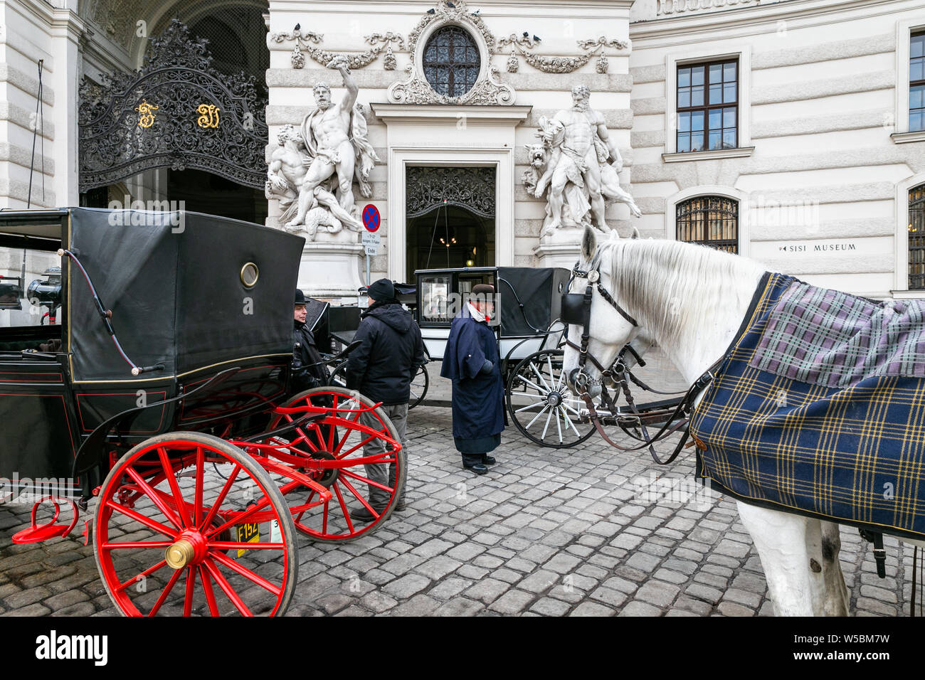 Kutschen und Menschen in der michaeler Platz warten, Michaelerplatz in Österreichischen. Michaeler Platz ist am Eingang zur Hofburg entfernt Stockfoto