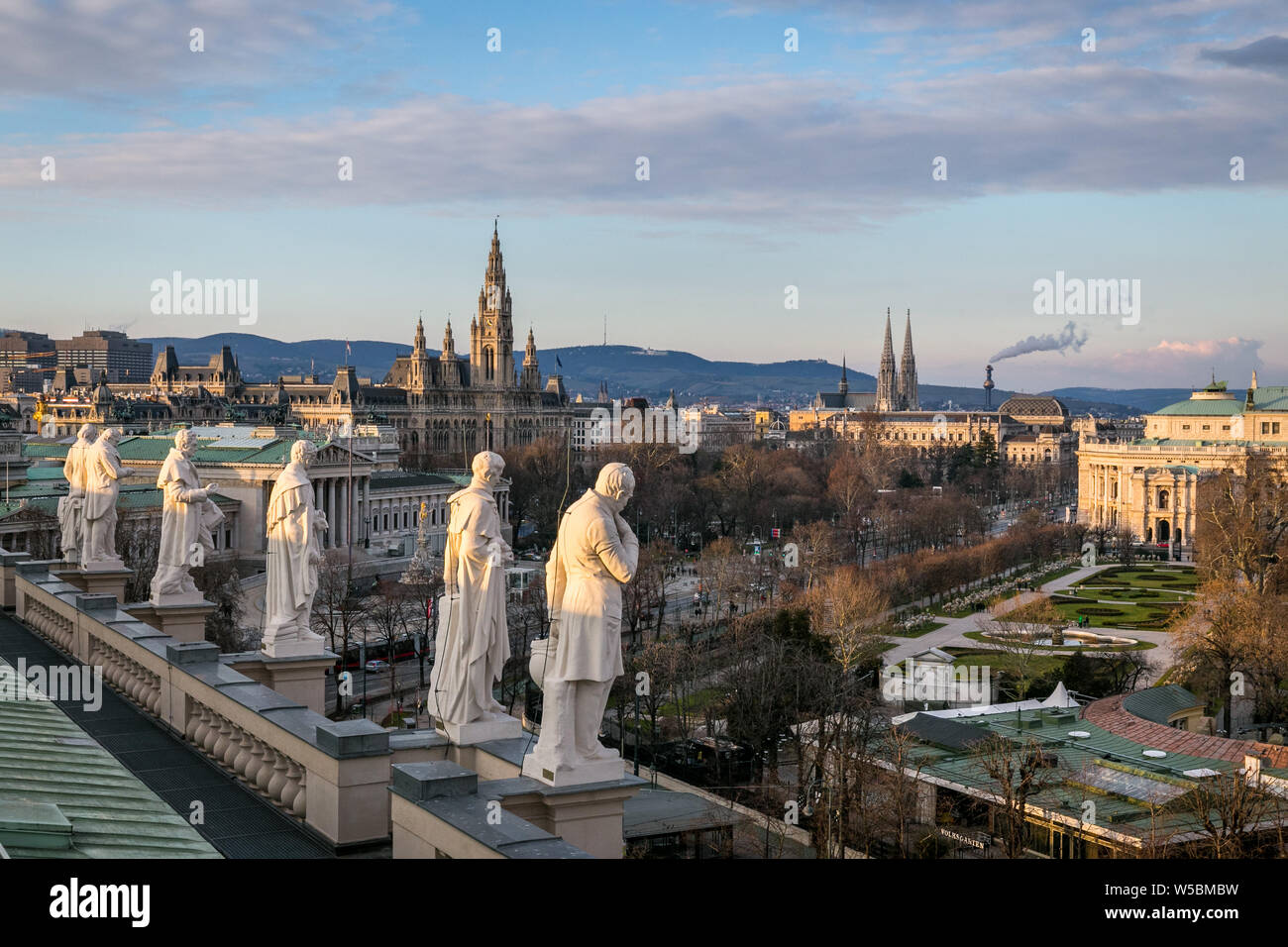 Statuen von berühmten Wissenschaftlern, auf dem Dach des Naturhistorischen Museums Ansicht mit dem Parlament und der Stadt Halle als schöne Stadtbild in Wien Stockfoto