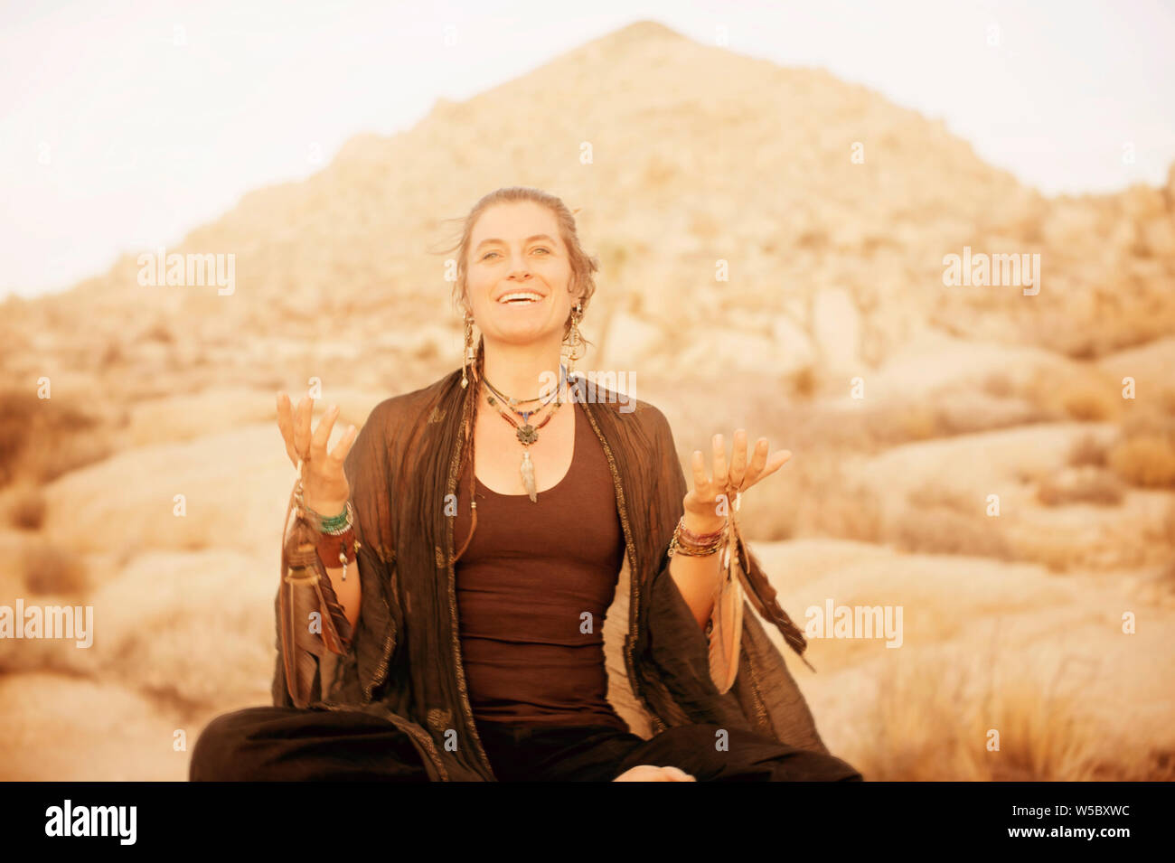 Schamane Frau arbeiten mit Raven und Hawk feather totem Energie in Joshua Tree, Kalifornien, USA Stockfoto