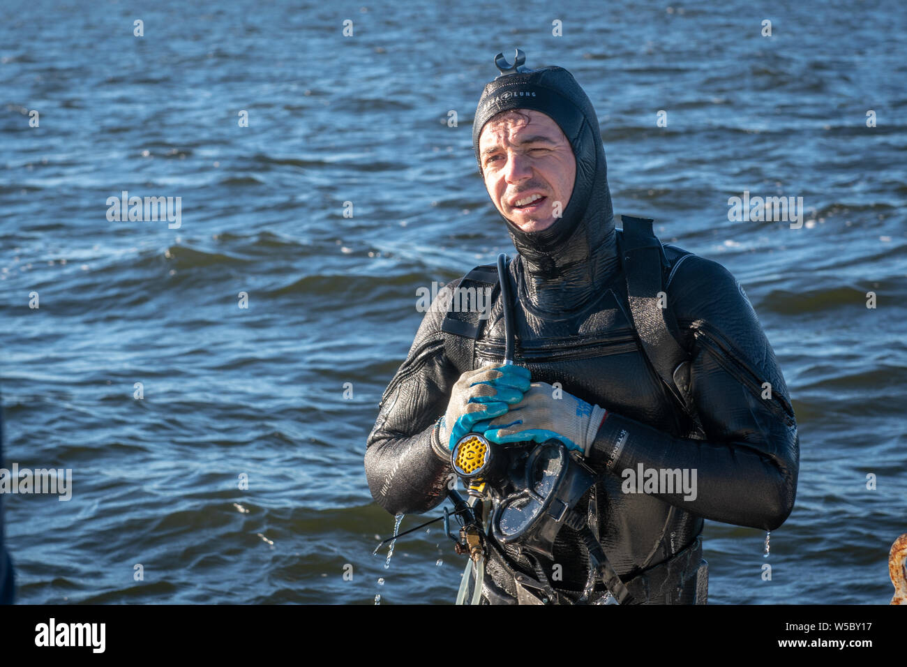 Eine wilde Oyster Diver bereitet und prüft seine Ausrüstung vor dem Tauchgang, Wittman, Maryland. Stockfoto