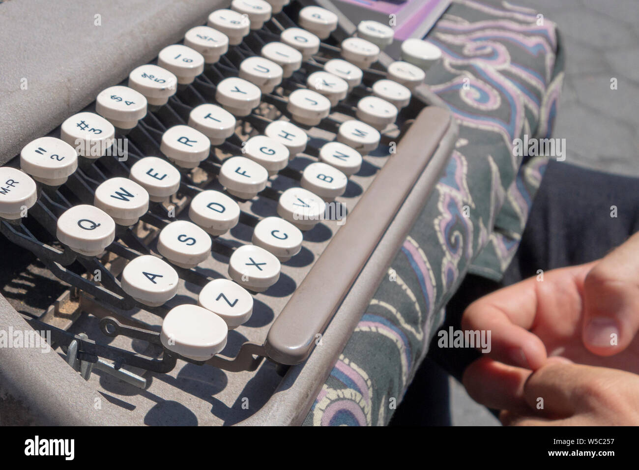 Mann mit Schriftstellern vor einer klassischen Schreibmaschine block Stockfoto