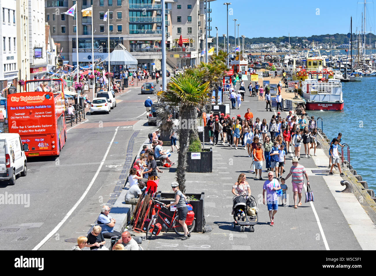 Poole Harbour View der Sommersaison Menschenmenge von oben gesehen zu Fuß entlang der Hafenpromenade Kai tour Boot & Marina über Dorset England UK Stockfoto