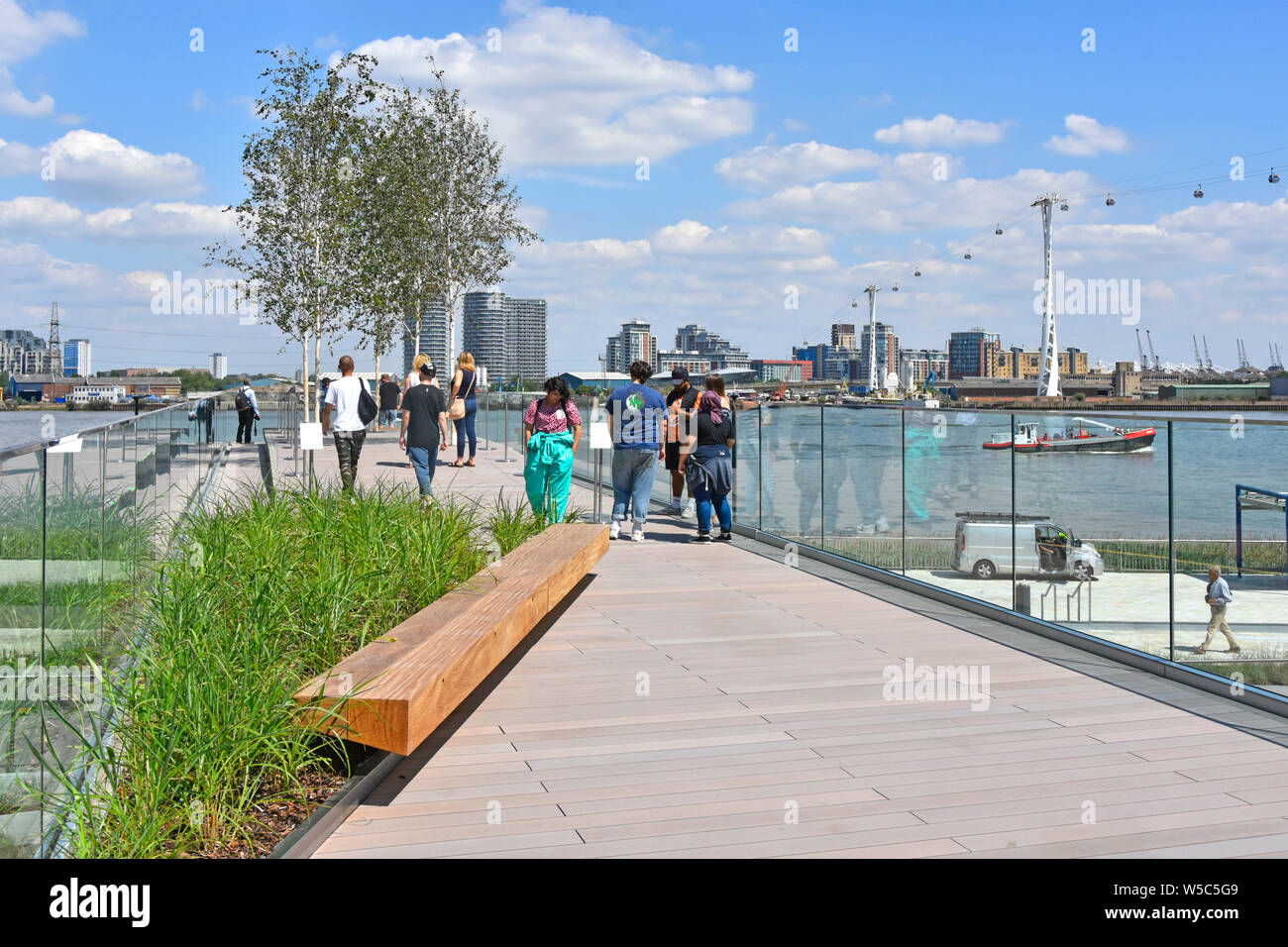Menschen zu Fuß die Flut Brücken eine lineare Parks links Themse Riverside mit erhöhten Spaziergänge rund um die Halbinsel südlich von Greenwich London England Großbritannien Stockfoto