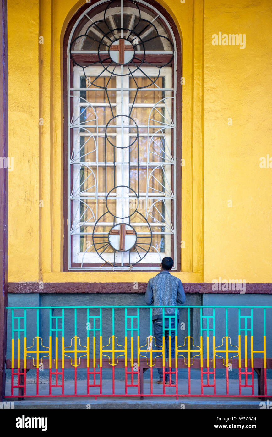 Ein Mann stand vor einem Fenster, Debre Berhan, Äthiopien Stockfoto
