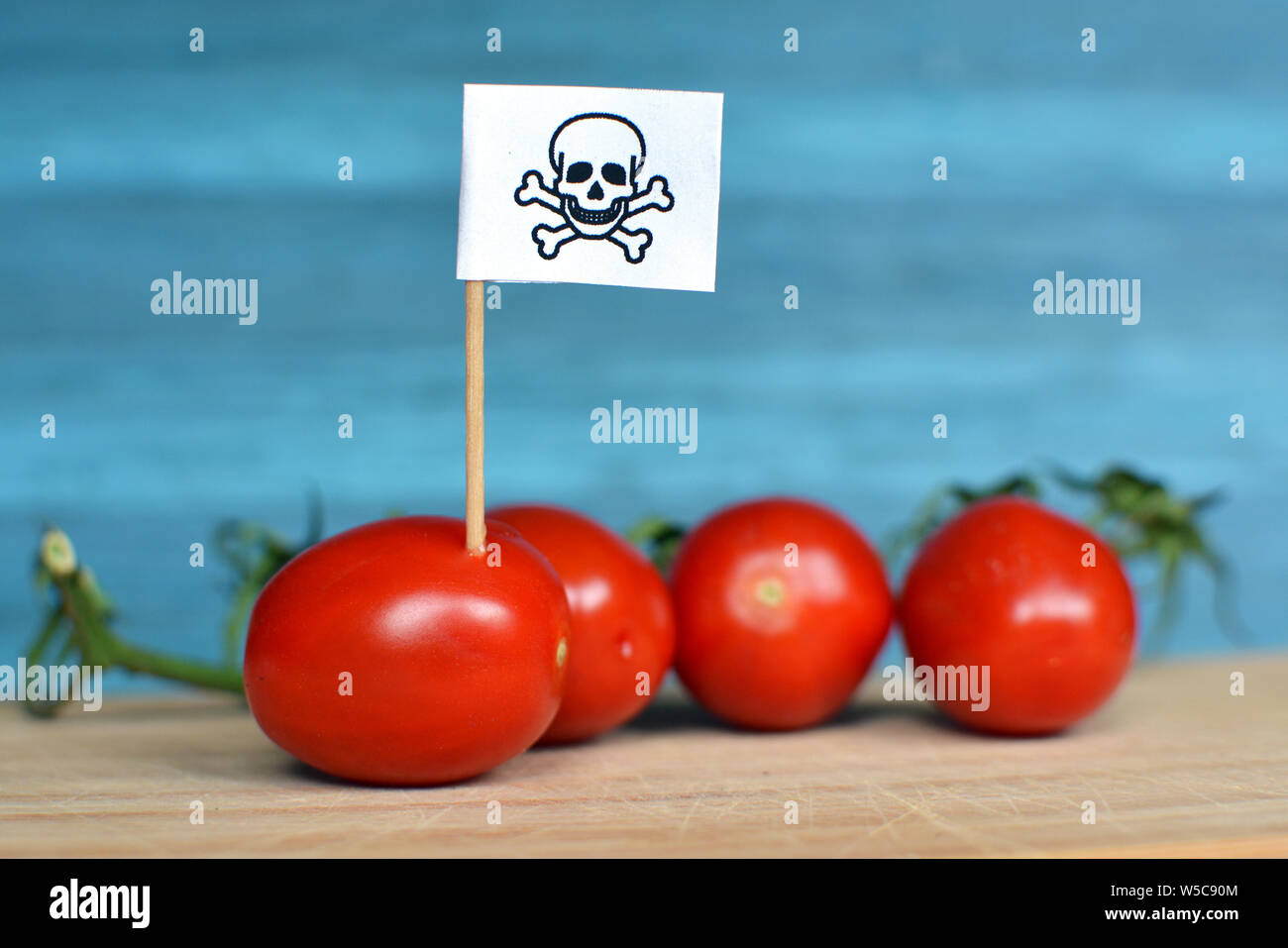 Konzept für den Einsatz gefährlicher Pestizide in der Landwirtschaft Lebensmittel mit roten Tomaten und toxische Warnschild Stockfoto