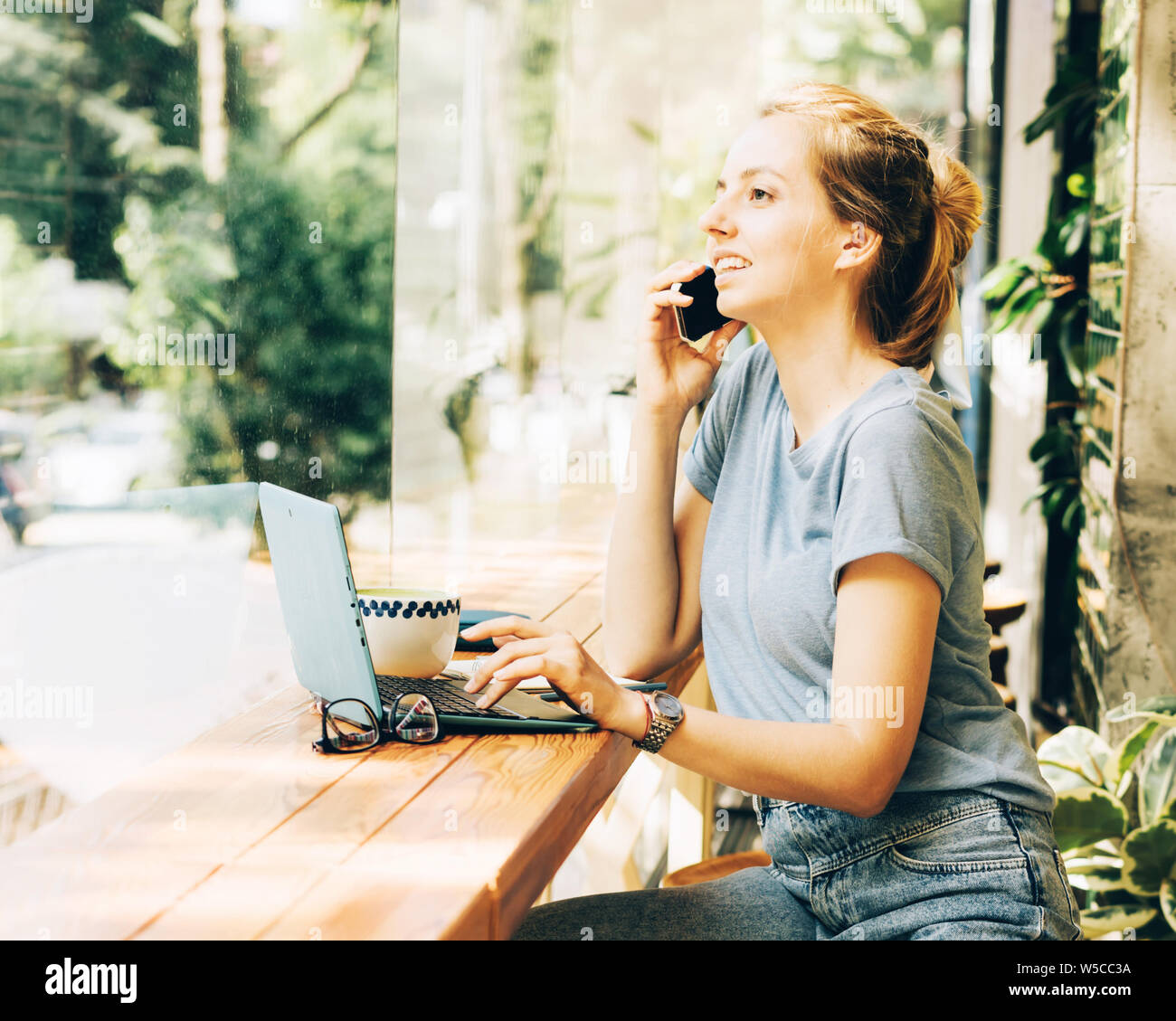 Business moderne zuversichtlich Mädchen, am Telefon zu sprechen, in einem Cafe an einem Tisch. Technische Geräte für die moderne Jugend Kommunikation. Stockfoto