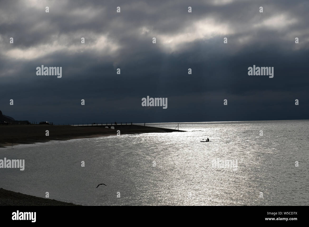 Hastings, East Sussex. 28. Juli 2019. Dramatisch dunklen Himmel heute morgen über ein Paddel boarder in Hastings Harbour, an einem kühleren, breezy Tag. Carolyn Clarke/Alamy leben Nachrichten Stockfoto