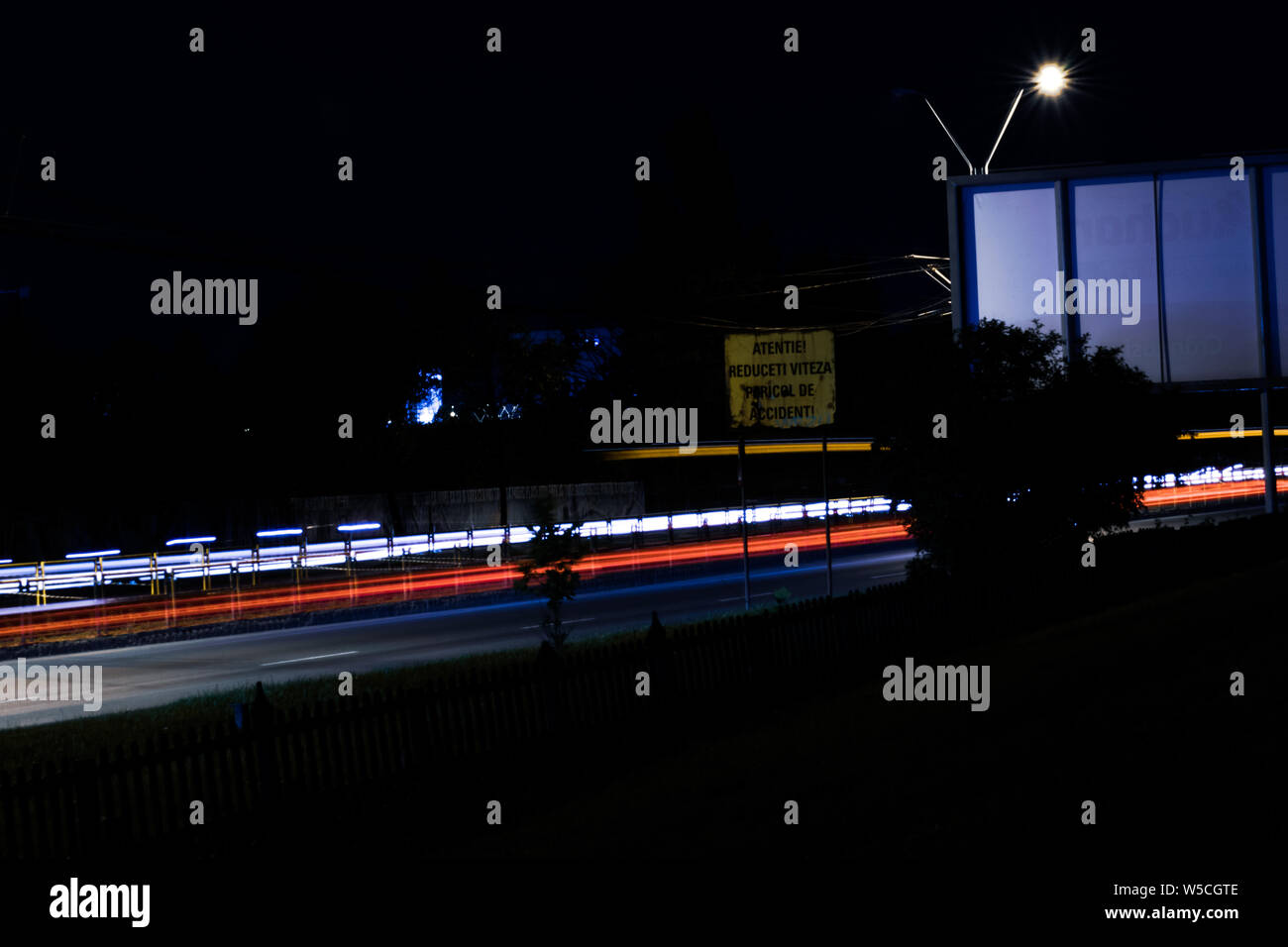 Lange Belichtung Foto von einer Straße in Rumänien, das moderne Leben Thema (der Straße Zeichen sagt: Aufmerksamkeit, Geschwindigkeit reduzieren, UNFALLGEFAHR) Stockfoto