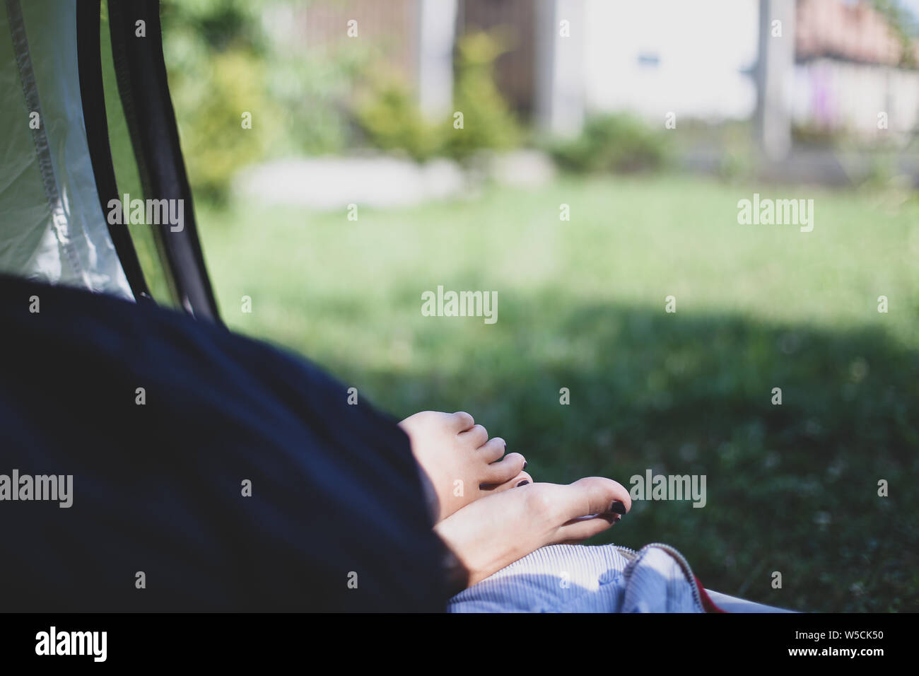 Details mit den Füßen einer Frau schlafen in einem Zelt bei einer Bergtour Stockfoto
