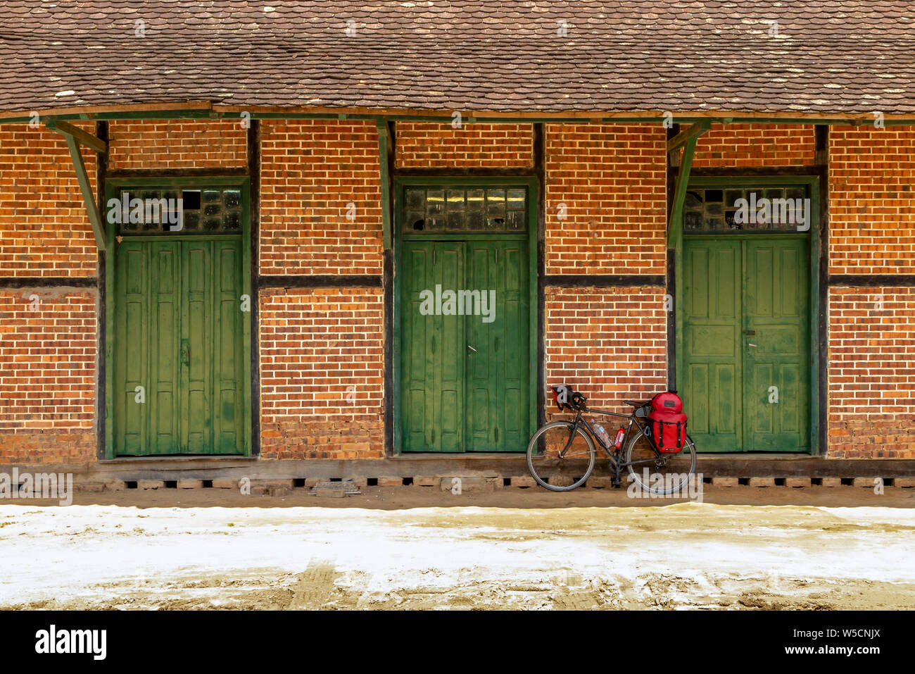 Vor der alten Fachwerkhaus mit grünen Türen, unbefestigte Straße und Radwandern Fahrrad vorwärts Stockfoto