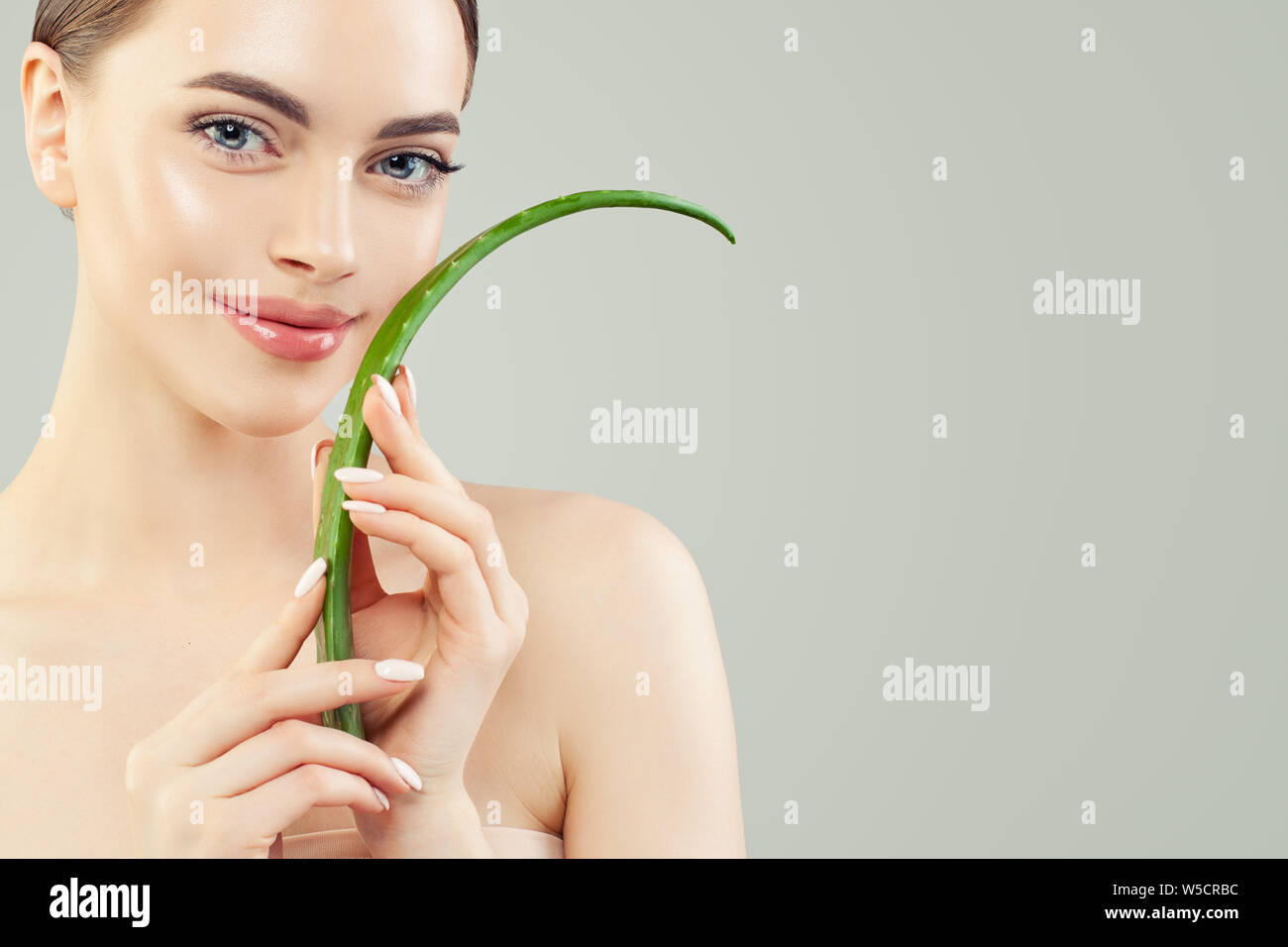 Natürliche Schönheit mit Aloe. Hübsche, junge Frau mit gesunder Haut und Aloe Vera Blatt in Ihren Händen, Hautpflege Konzept Stockfoto