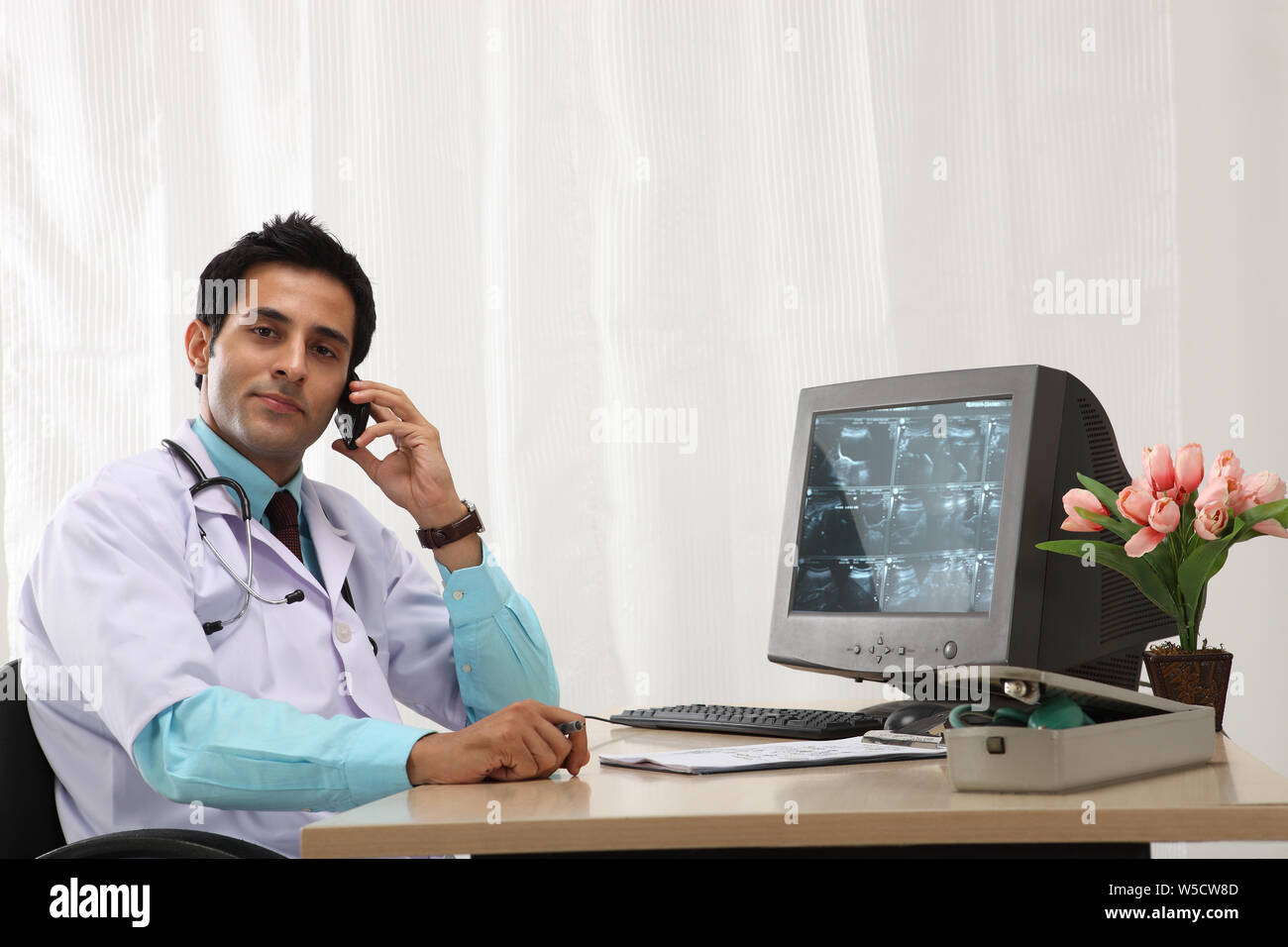 Männlicher Arzt Gespräch am Handy im Krankenhaus Stockfoto