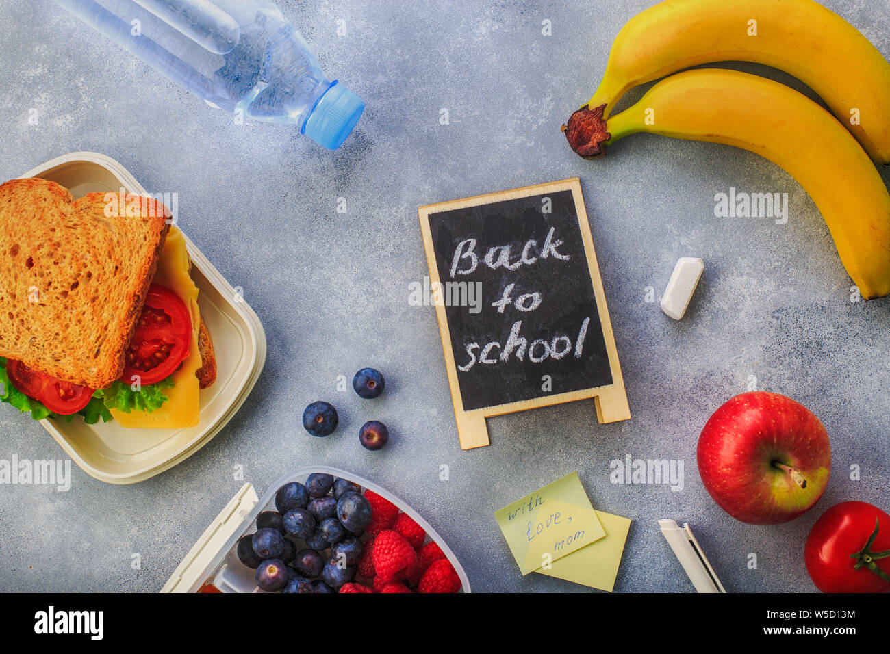 Lunchboxes mit Sandwiches und verschiedene Produkte auf grauem Hintergrund Stockfoto