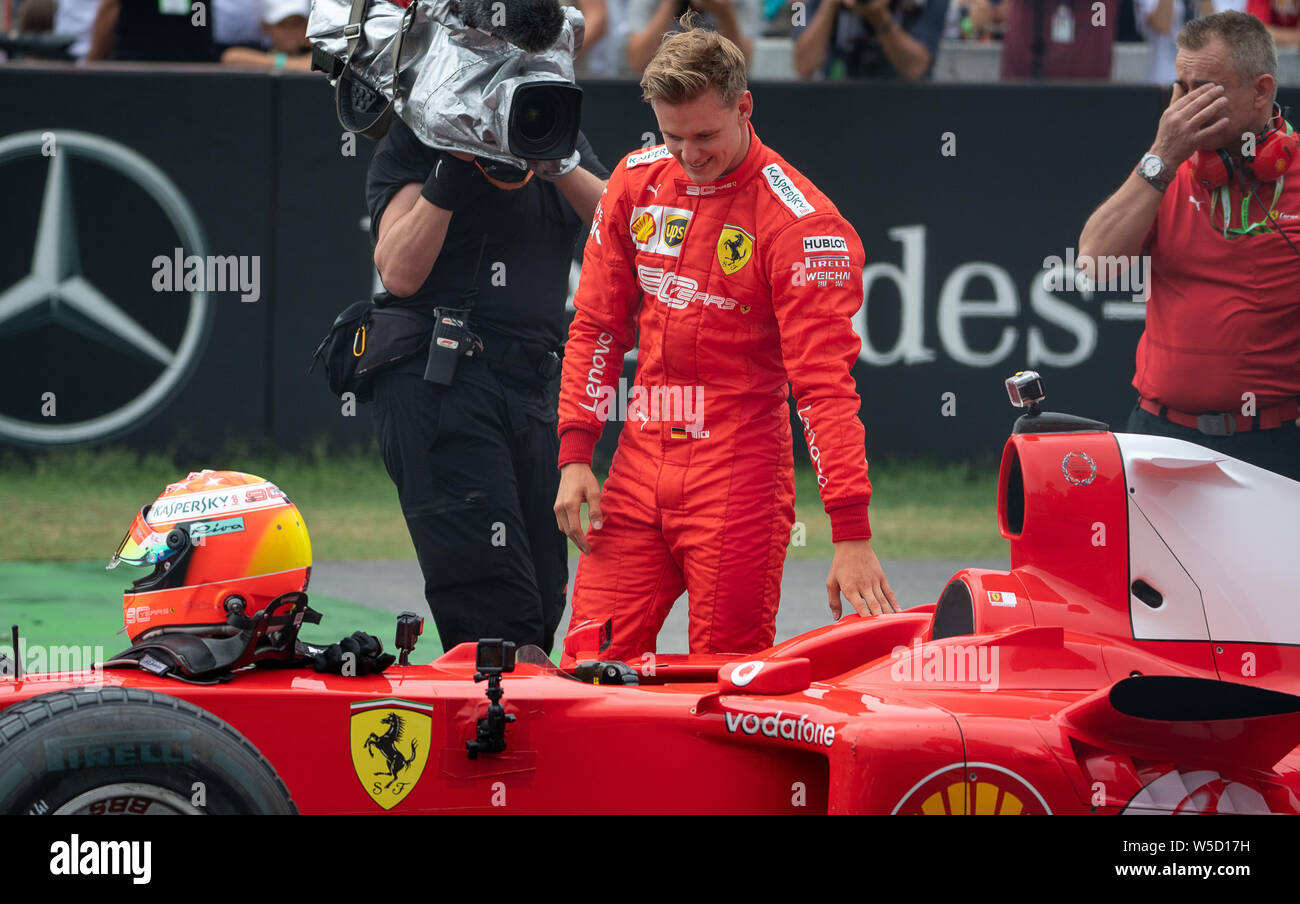 Hockenheim, Deutschland. 28. Juli 2019. Motorsport: Formel 1-Weltmeisterschaft, den grossen Preis von Deutschland. Mick Schumacher, Formel 2-Fahrer, steht auf dem Hockenheimring neben dem Auto nach der Fahrt Auto seines Vaters, der Formel 1-Fahrer Michael Schumacher. Credit: Sebastian Gollnow/dpa/Alamy leben Nachrichten Stockfoto