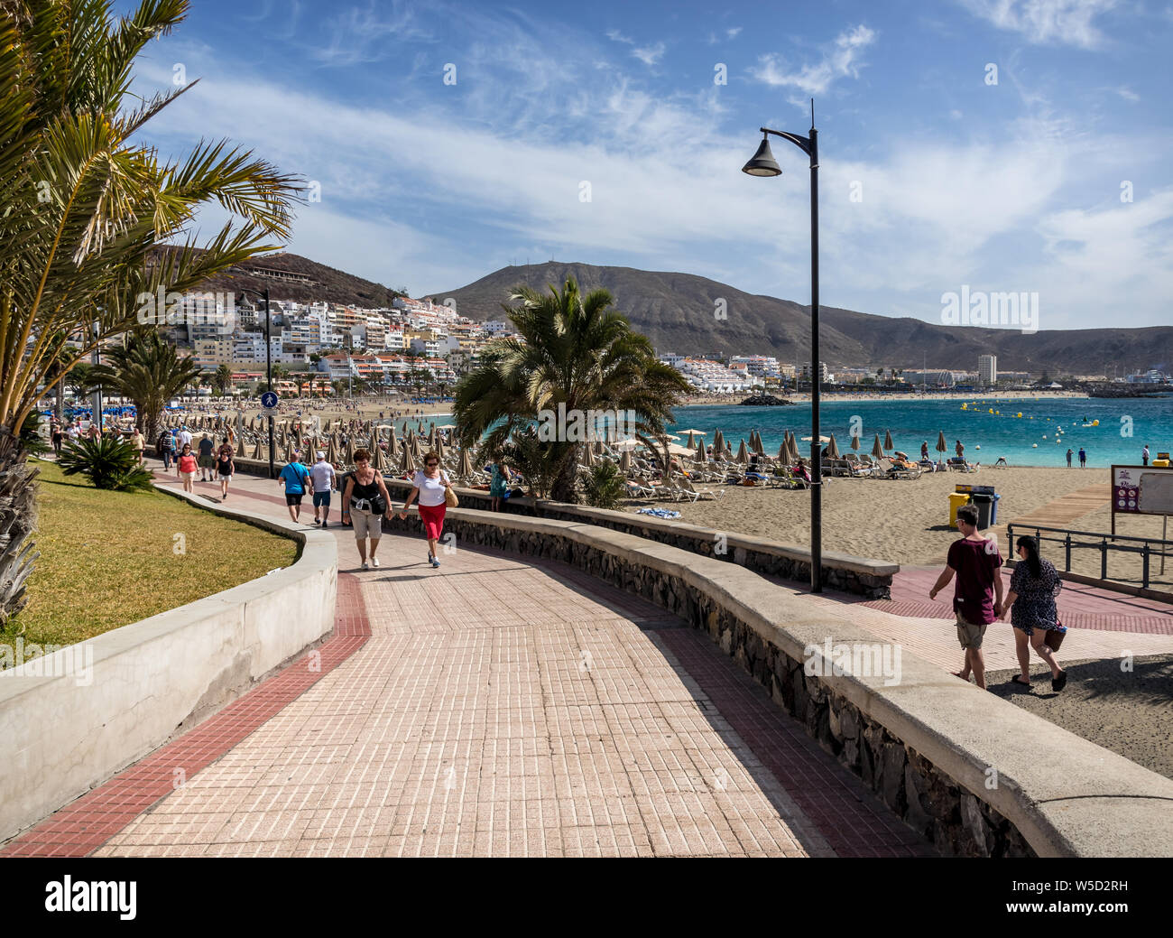 Menschen entspannen und genießen Sie die warme Sonne am Strand Playa de Los Cristianos Stockfoto