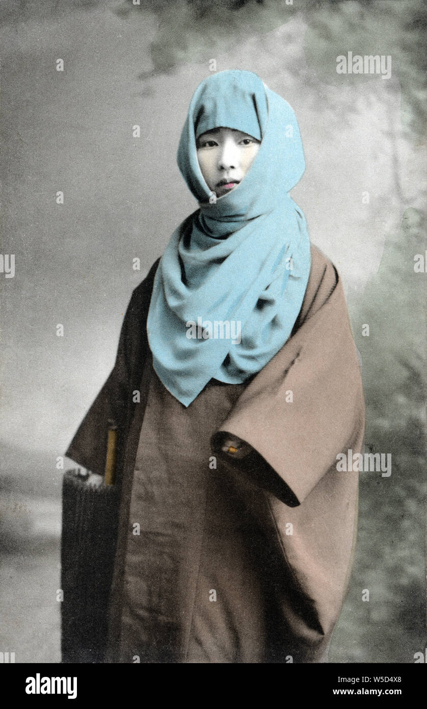 [1900s Japan - Japanische Frau im Winter Kleidung] - eine Frau eine okosozukin (御高祖頭巾) um den Kopf wickelte sich gegen die Winterkälte zu schützen. 20. jahrhundert alte Ansichtskarte. Stockfoto