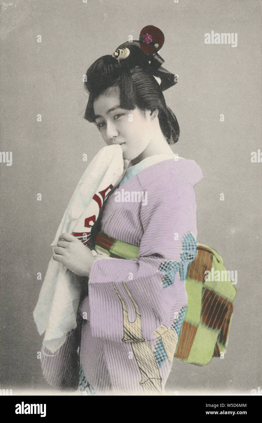 [1880s Japan - Japanische Geisha] - Junge japanische Geisha im Kimono und traditionelle Frisur Holding ein Handtuch, 1880. 20. jahrhundert alte Ansichtskarte. Stockfoto