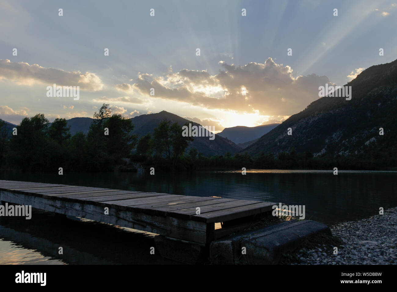 Lichtstrahlen, die während der Goldenen Stunde über einem See in Südfrankreich Stockfoto