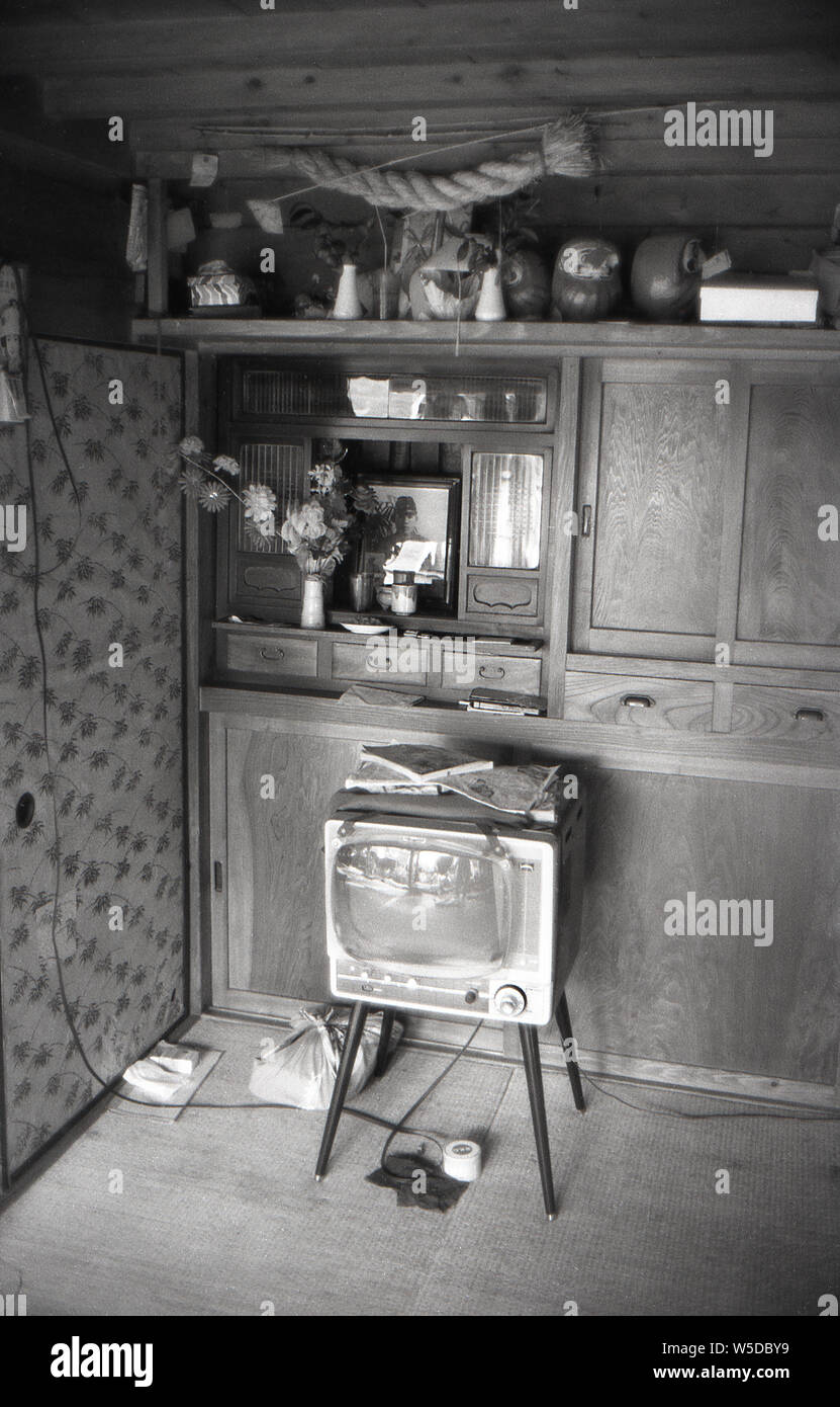 [1950er Jahre Japan-religiösen Altar an einem privaten Haus] - Einrichtung eines privaten Hauses mit TV; ein Kamidana (神棚), einer Miniatur Haushalt Shinto Altar; und ein Saidan Schrein (祭壇) mit Opfergaben vor ein Foto von einem Familienmitglied getötet während des zweiten Weltkriegs, 1958 (Showa 33). Stockfoto