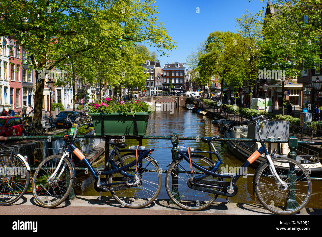 Fahrräder, die auf der Brücke, die den Kanal in Amsterdam, Niederlande, Kreuze Stockfoto