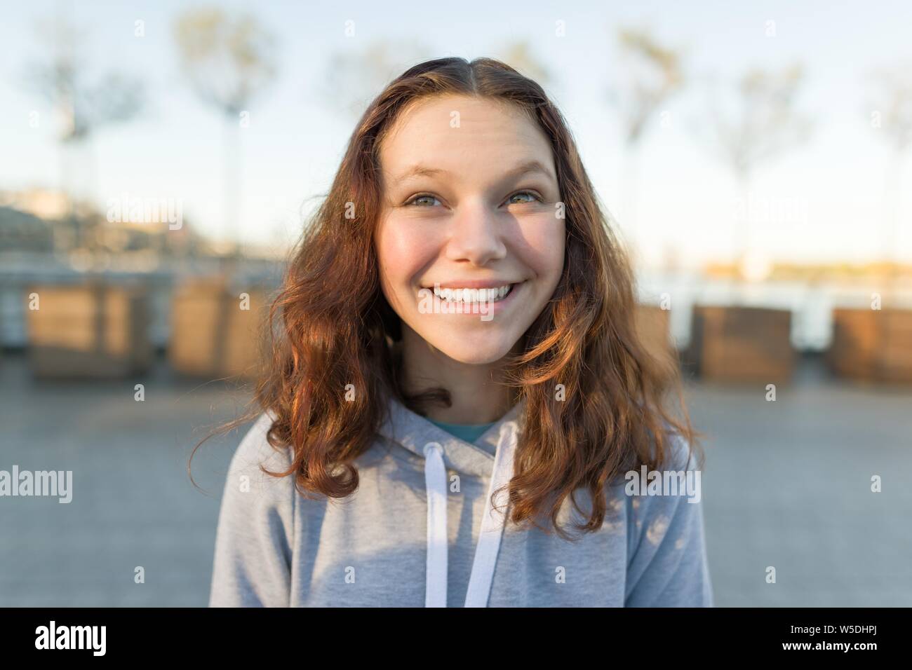 Outdoor Portrait von schönen lächelnden Teenager Girl 14, 15 Jahre alten, goldenen Stunde Stockfoto