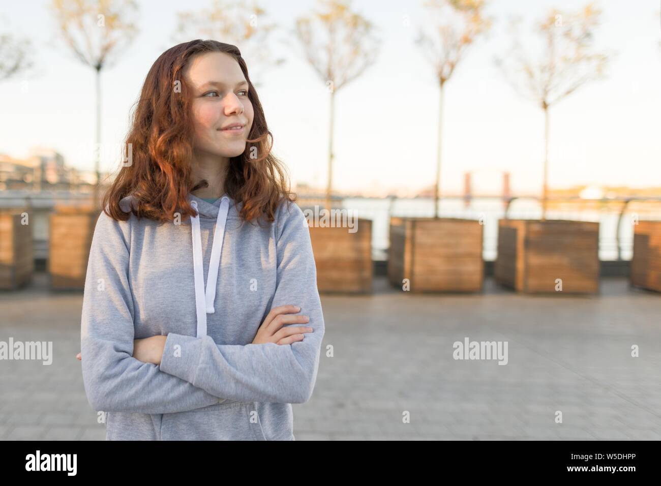 Outdoor Portrait von schönen lächelnden Teenager Girl 14, 15 Jahre alten, goldenen Stunde Stockfoto