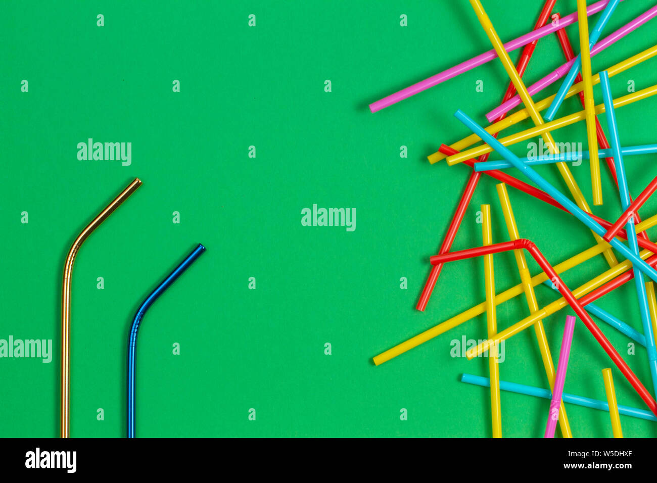 Edelstahl wiederverwendbare Trinkhalm mit vielen bunten Plastik Strohhalme auf hellgrüner Hintergrund Stockfoto