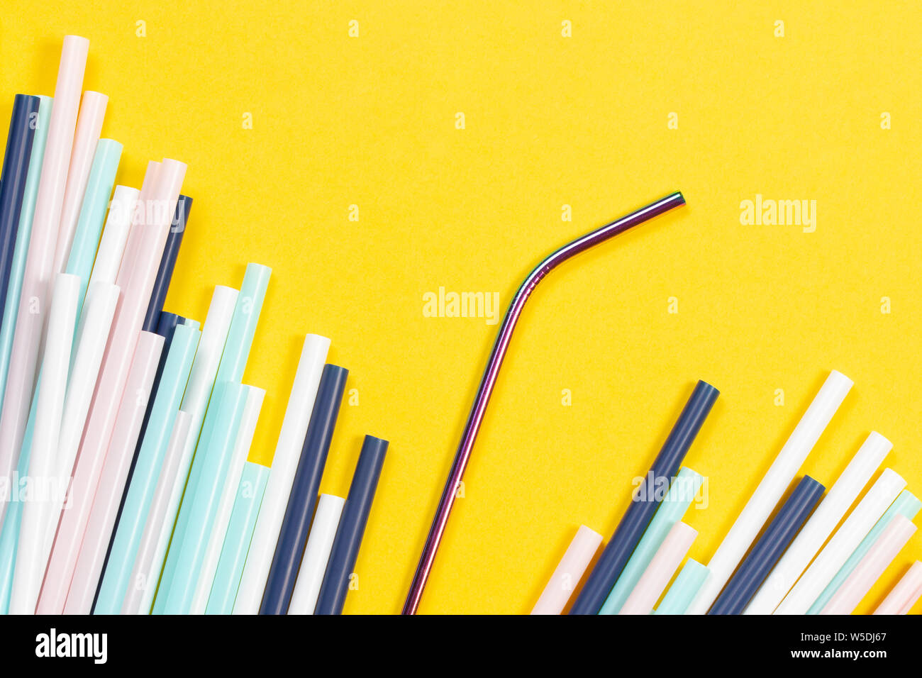 Edelstahl wiederverwendbare Trinkhalm mit vielen bunten Plastik Strohhalme auf gelbem Hintergrund Stockfoto