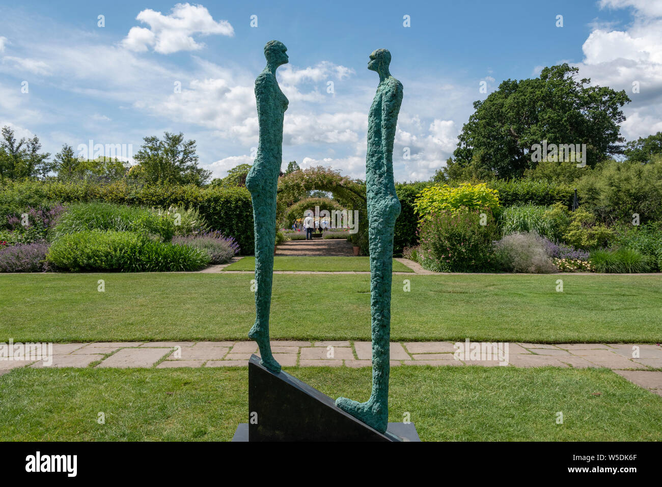 Bronze Skulptur in der gemischten Grenzen mit Blick in Richtung der Cottage Garden, an der RHS Wisley, der Royal Horticultural Society. Stockfoto