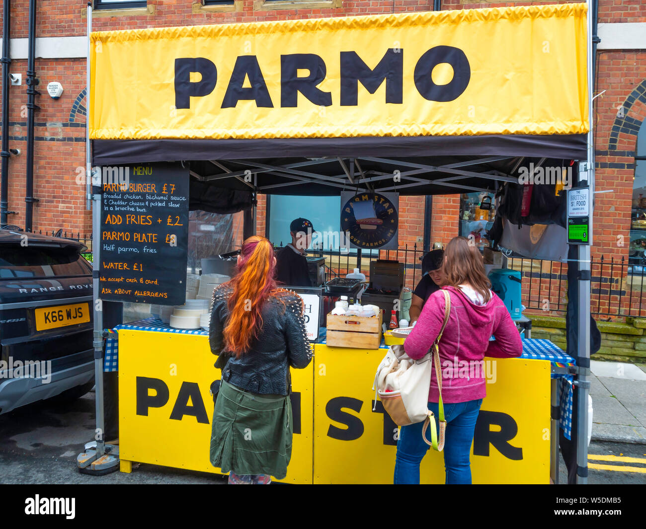 Jährliche Saltburn Food Festival 2019 einen Stall verkaufen Parmos ein beliebtes Gericht im Nordosten frittierte paniertes Huhn Béchamelsauce und geschmolzenem Käse Stockfoto