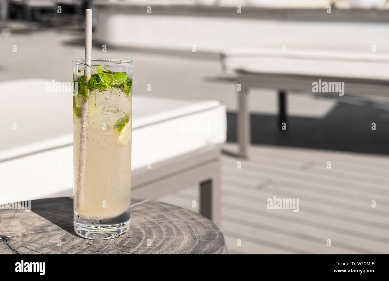 Virgin Mojito mit Papier Stroh auf einen hölzernen Tisch in der Nähe einer luxuriösen Liegestühlen. Sommer Urlaub trinken. Stockfoto