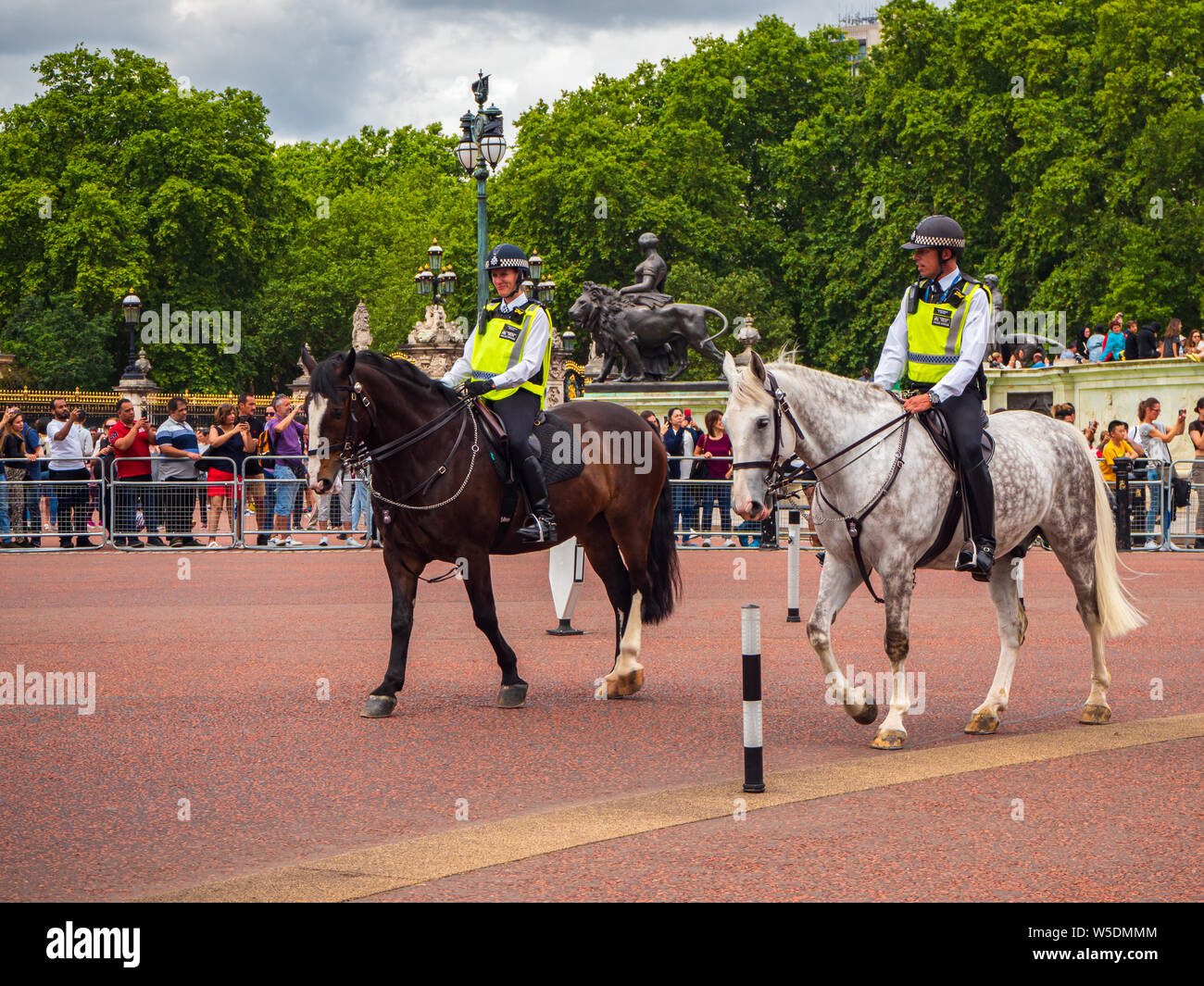 Berittene Polizei zu Pferd Patrouillen außerhalb der Buckingham Palace in England von den Massen der Touristen umgeben Stockfoto