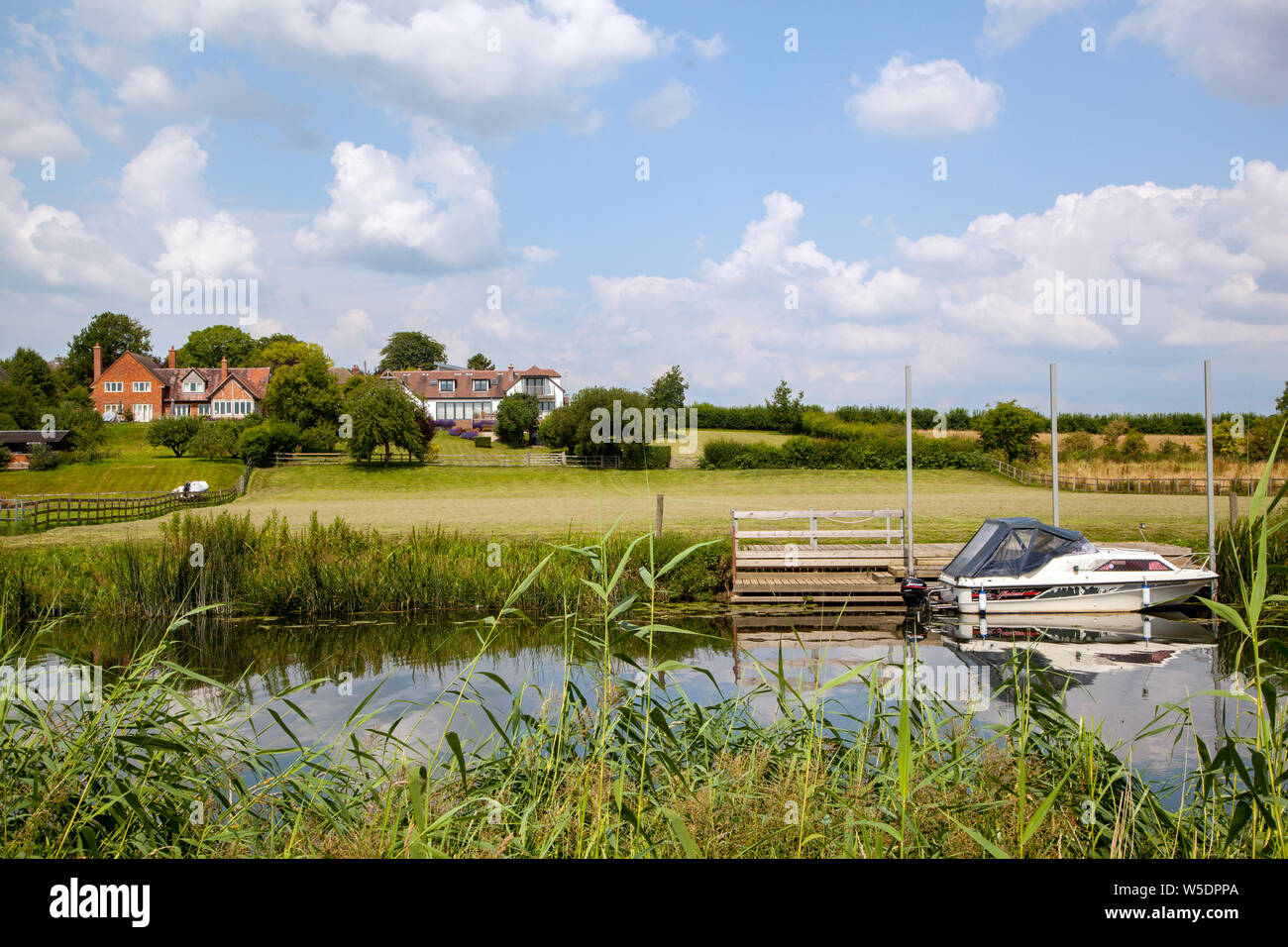 Ruhige Szene auf dem Fluss Avon in Warwickshire in England mit einem Boot an der Unterseite eines Landes Haus Garten günstig Stockfoto