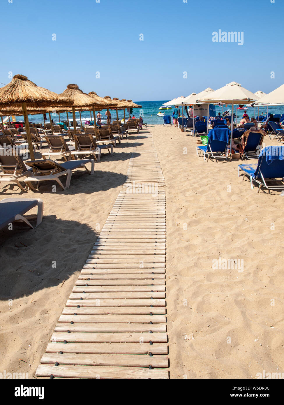 Malia, Kreta, Griechenland - Dezember 18, 2019: die Menschen ruhen auf einem sonnigen Tag am Strand in Malia, Kreta, Griechenland Stockfoto